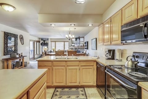 Your spacious kitchen features warm wood cabinets, ample counter space, and all modern appliances for preparing memorable meals together.