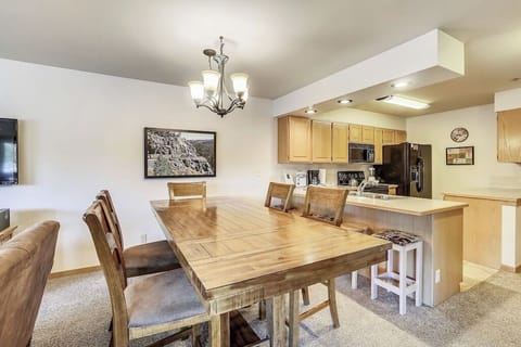 Gather around your rustic wooden dining table where warm conversations flow seamlessly into your fully-equipped kitchen.