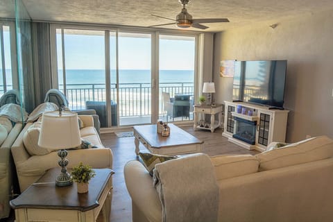 Sink into plush sofas as you watch waves roll onto the beach through floor-to-ceiling windows, with cozy fireplace and spacious living for perfect evenings.