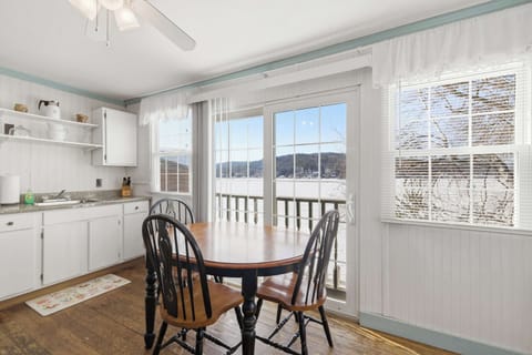 The kitchen table seats four with the lake filling the windows — a hard view to beat over morning coffee.