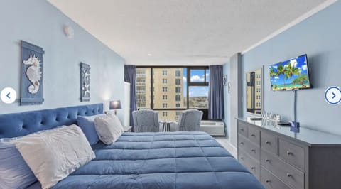 View of cozy 603 with comfy king sized bed, smart TV, and seating area