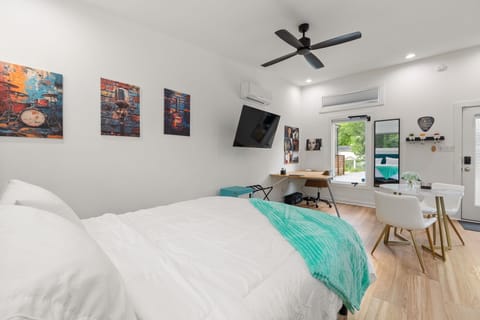 Bright modern studio with workspace, dining area, and garden-view door