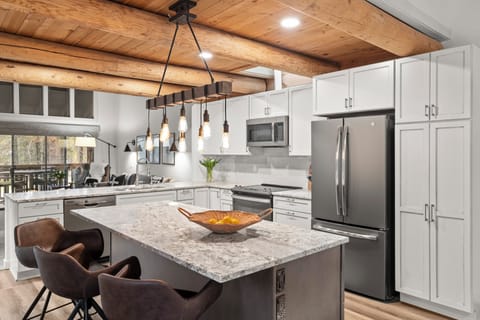 Your fully equipped gourmet kitchen features granite counters, stainless appliances, and rustic wood beams—perfect for cooking memorable meals together.