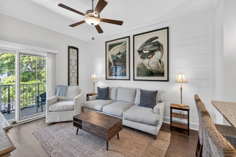 Living room with shiplap wall and patio overlooking pool.
