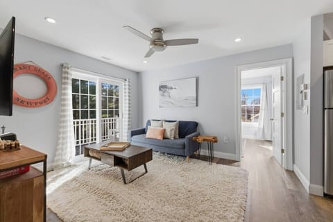 Living room with TV and entrance to a private deck