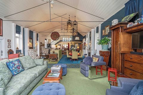 Unwind beneath soaring ceilings in the main living area, where plush seating, warm lamplight and split-system heating and cooling create a comfortable setting for slow mornings or relaxed evenings in.