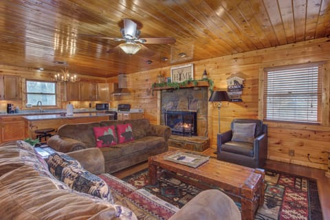 Cozy up by your crackling stone fireplace while you unwind on plush sofas in this warm, wood-paneled cabin retreat.