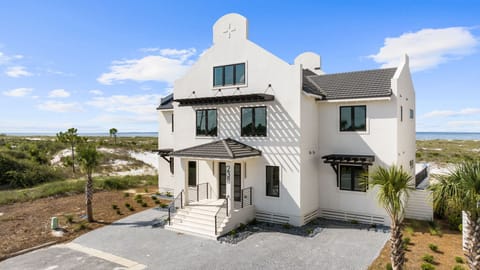 Striking white coastal architecture with distinctive design elements nestled between natural dunes and pristine beach access.