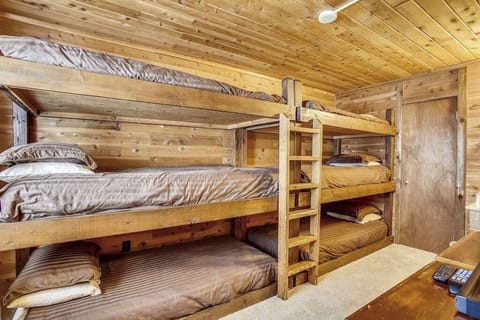 Cozy up in your rustic wooden bunk room where warm wood surrounds you and comfy bedding awaits restful mountain nights.