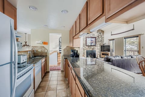 Your fully equipped kitchen features granite counters and opens to a cozy living area with stone fireplace.