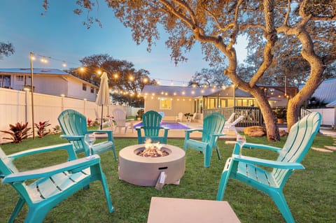 Backyard fire pit with comfy seating and warm string lights