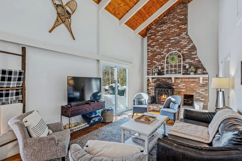 Living room with wood-burning fireplace, leather sofa, and Smart TV