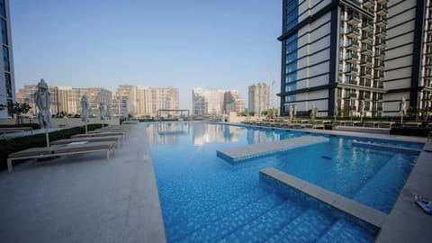 Shared swimming pool with sun loungers in Dubai Hills Estate.