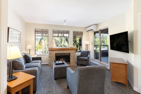 Unwind by the glowing fireplace with treetop views outside.