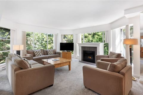 Unwind by the glowing fireplace with sweeping forest views.