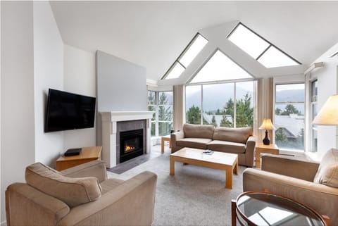 Gather by the glowing fireplace as mountain views fill windows.