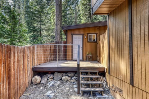 Private entrance with a small deck surrounded by trees, offering a quiet and secluded access point to the unit.
