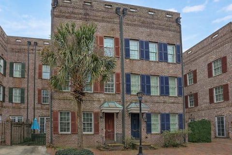 Classic Savannah charm welcomes you to The Red Brick on Hull — a beautiful three-story townhome with timeless brick architecture and signature red shutters.