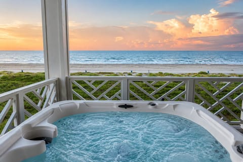 Private hot tub overlooking the Gulf of Mexico, offering bubbling water, built-in seating and unobstructed beach views from the covered balcony of this Galveston rental.