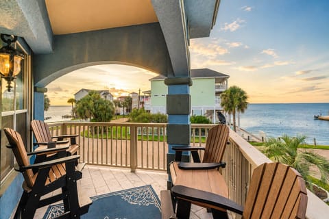 Private covered balcony with Adirondack seating and relaxing waterfront views, creating an inviting place to enjoy fresh air and the coastal scenery in Galveston.