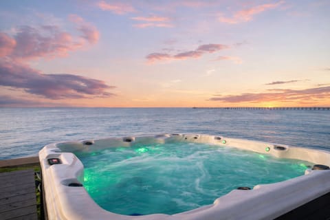 Relaxing waterfront hot tub overlooking West Bay with breathtaking sunset views at this Galveston bayfront vacation rental.