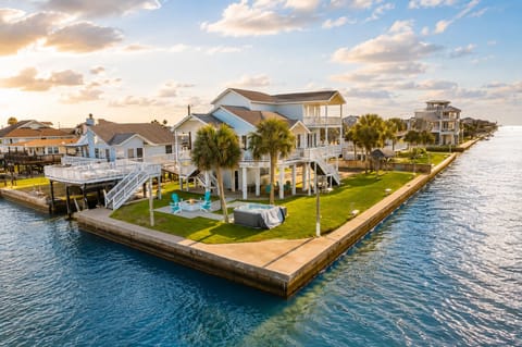 Drone aerial of luxury West Bay bayfront home with private dock in Galveston.
