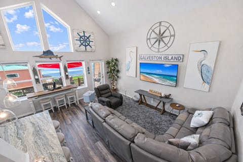 Bright coastal-style living room with comfortable seating, beach décor, and open layout designed for relaxing family vacations in Galveston.