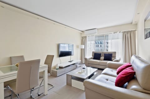 Espace de vie chaleureux avec canapés, TV connectée et coins repas