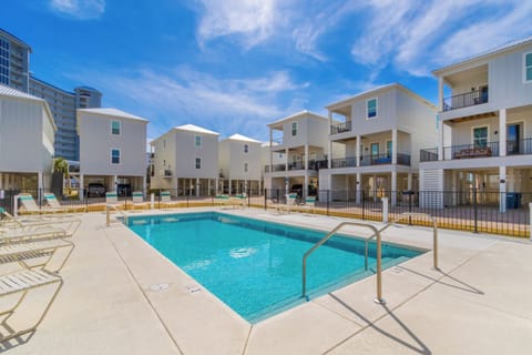 Pool surrounded by coastal cottages.