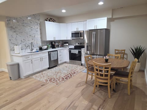Fully loaded modern kitchen with stainless appliances, big dining table, and ton