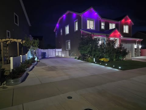 Halloween lights — purple & orange LEDs, well-lit driveway.