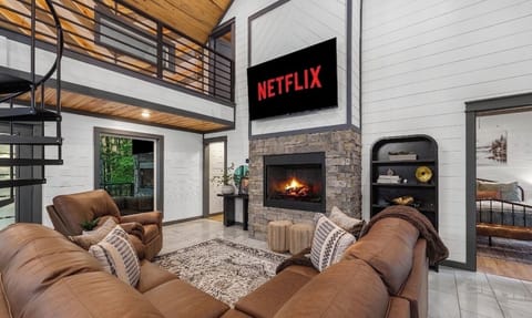 Cozy living room with TV, comfy seating, and calming forest views