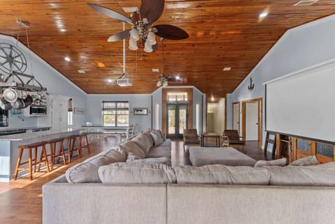 Spacious living room with large sectional and vaulted wood ceilings
