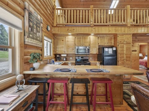Kitchen | Gas Range & Coffee Maker | Wood Cabinetry & Island Seating
