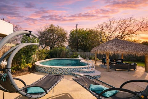 Resort-style private pool with tropical tiki bar and lounge seating at Galveston vacation rental near the beach.