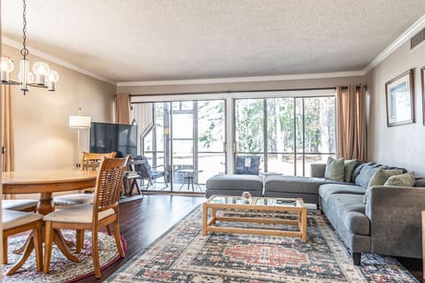 Spacious living area with comfortable sectional seating, dining table, and large sliding doors leading to a private patio.