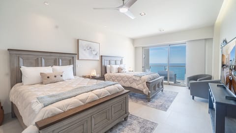 the main room with beds, TV, and balcony access