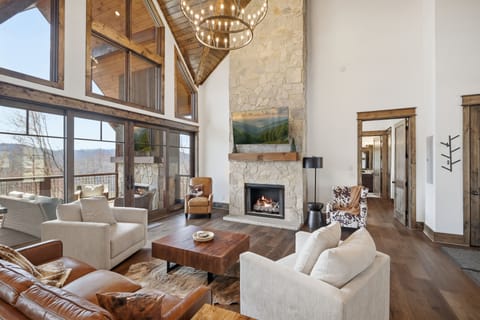 Cozy living room with stone fireplace, TV & stunning mountain views