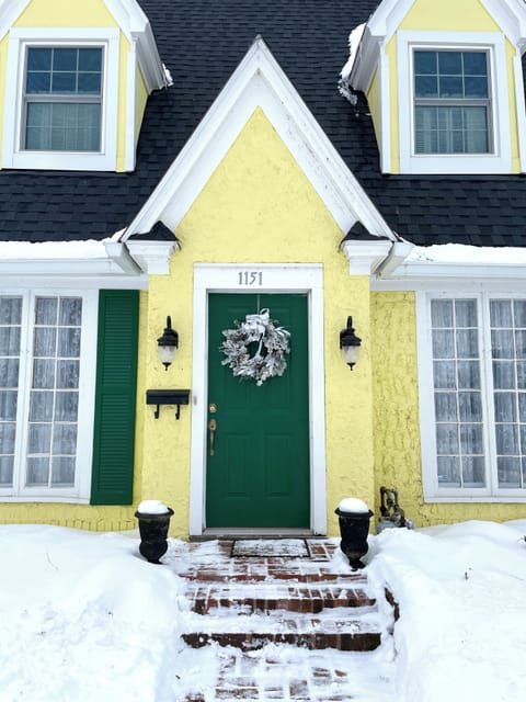 Welcome home! 🌿🏡 This inviting yellow cottage with its bold green door and charming wall lanterns makes a first impression you'll never forget — your retreat is ready and waiting for you.