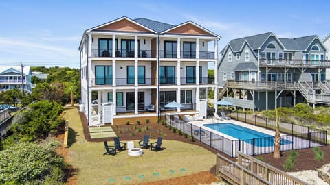 Stunning coastal vacation home with private pool, spacious yard, and multiple balconies in a peaceful beachside neighborhood.