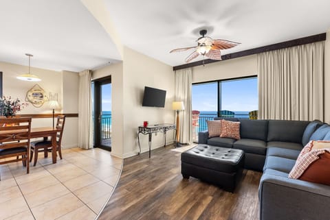 Unwind in your bright living space with stunning ocean views through floor-to-ceiling windows and a comfortable sectional for relaxing.