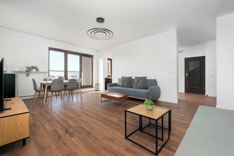 lIving room showing the sofa and coffee table from a different angle. The room looks spacious and modern with simple décor and natural light.