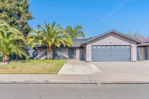 Charming exterior with lush palms and a welcoming entry for your Fresno getaway!