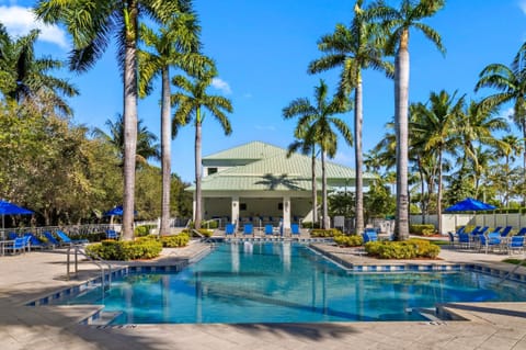 Resort pool overlooking the clubhouse, featuring ample seating and a bright, open layout.