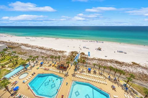The Summit's beachfront pool glistens under the Florida sun, surrounded by loungers and just steps from the sugar‑white sand.