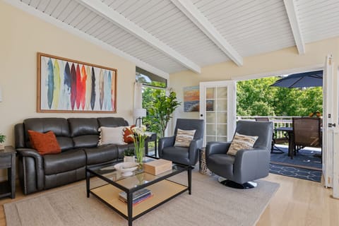 Upper level living space is sun-filled and surrounded by lush park views and peaks of the ocean.