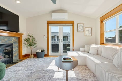Bright living room w/ a plush sofa, warm wood trim & large windows that fill the space w/ natural light.
