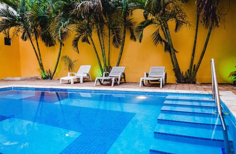 Stretch out on loungers beside sparkling blue water and palms.