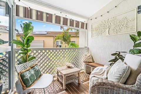 Enjoy a quiet morning coffee or a relaxed evening drink on the private balcony, where woven seating and soft cushions create a comfortable outdoor nook.
