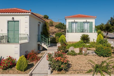 Charming exterior of the villa surrounded by colorful gardens and mountain views.